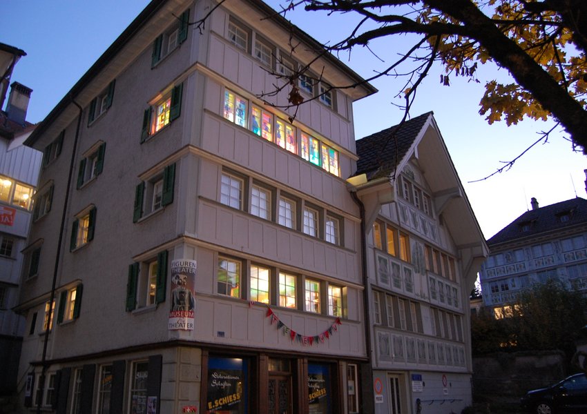 In the evening, the museum windows light up the alley: the «Laterne» with shadow puppets.